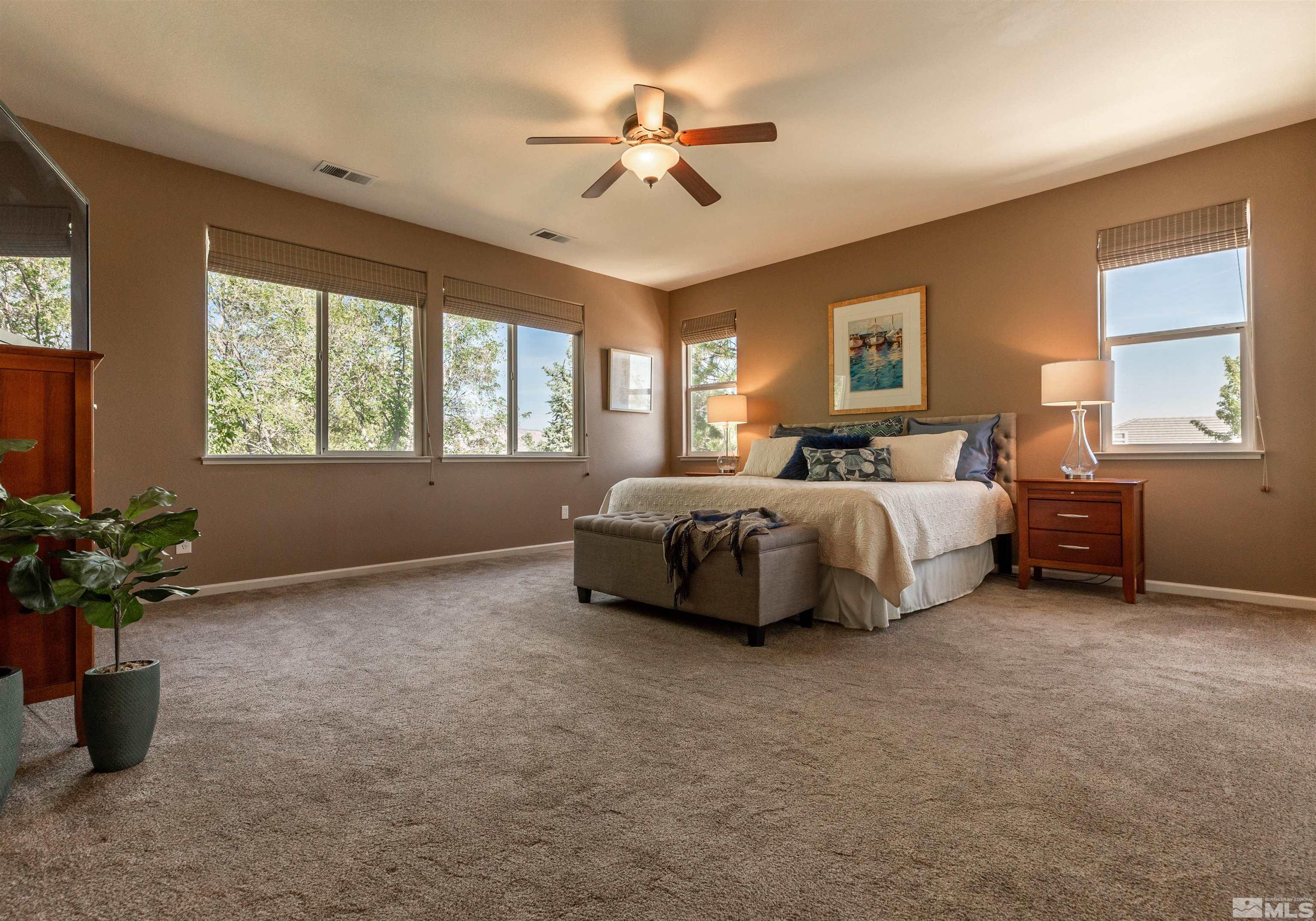 4829 Ramcreek Trail Reno, NV 89519 - Photo 16 of 40 a spacious bedroom with a bed and a chandelier