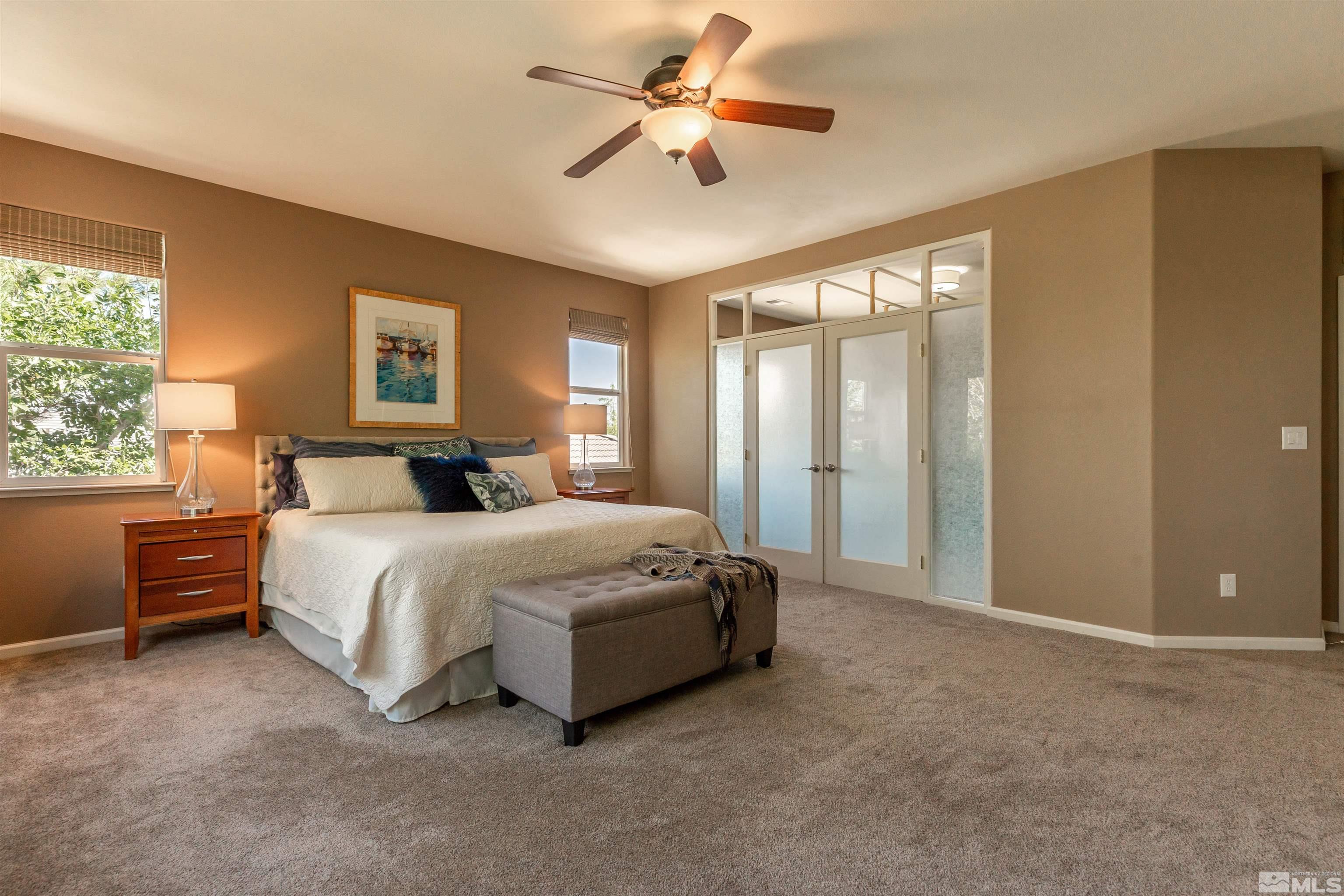 4829 Ramcreek Trail Reno, NV 89519 - Photo 17 of 40 a spacious bedroom with a bed and a chandelier