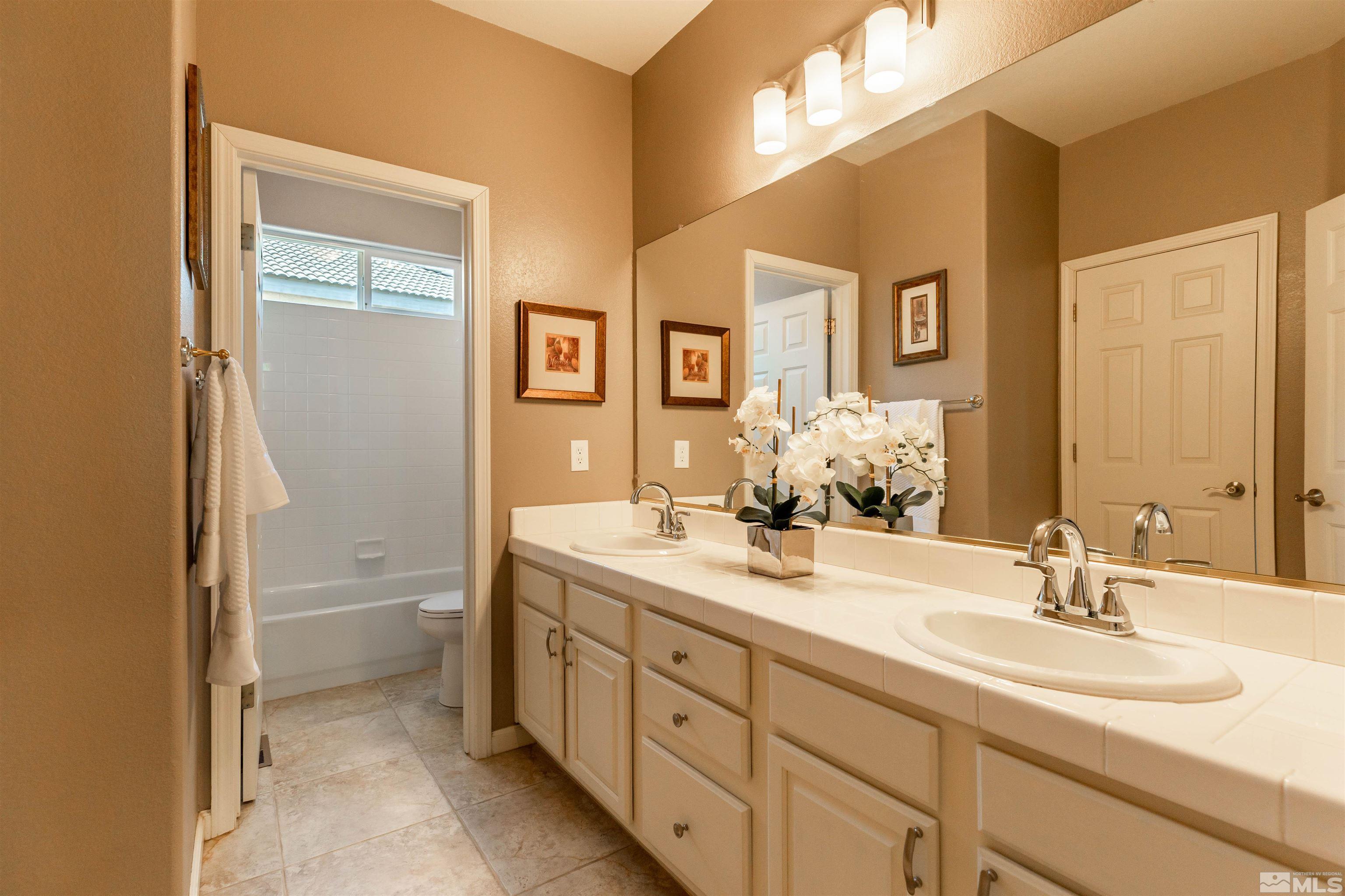 4829 Ramcreek Trail Reno, NV 89519 - Photo 23 of 40 a bathroom with a granite countertop sink toilet and a mirror