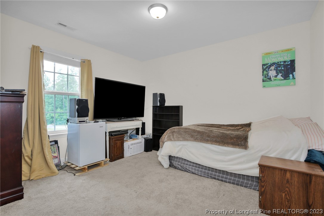 90 Eaker Drive Cameron, NC 28326 - Photo 20 of 36 a bedroom with a bed and a flat screen tv