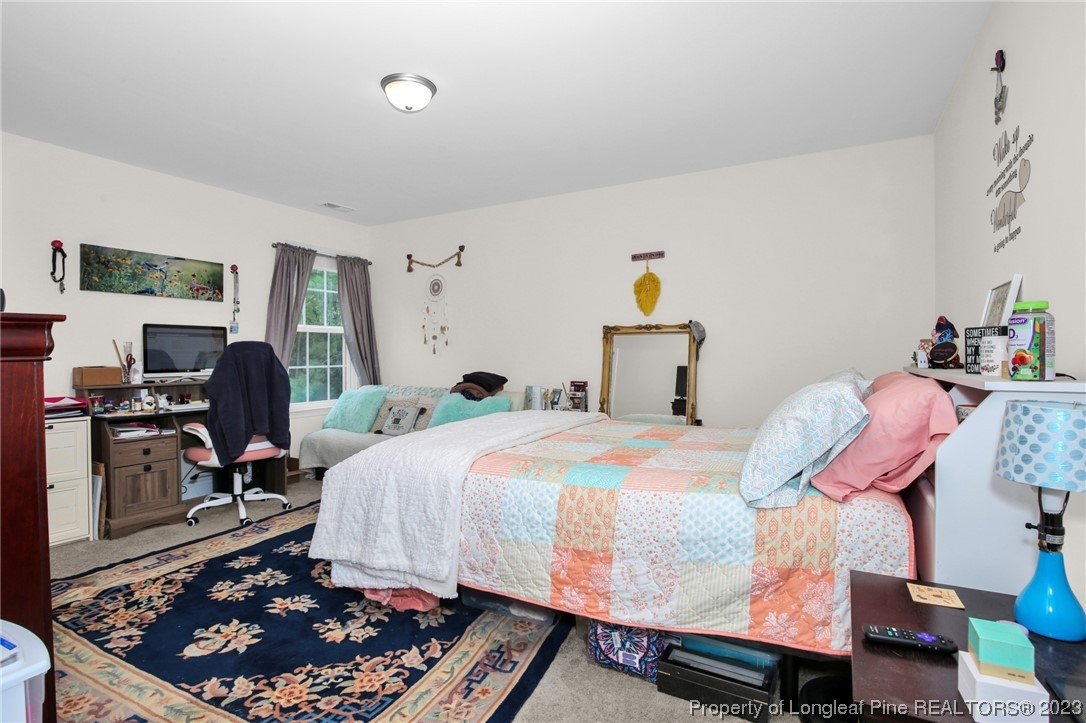 90 Eaker Drive Cameron, NC 28326 - Photo 28 of 36 a bed room with a bed a chair and a potted plant