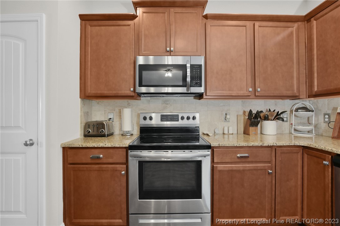 90 Eaker Drive Cameron, NC 28326 - Photo 6 of 36 a kitchen with granite countertop a stove a sink and a microwave