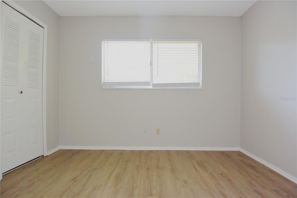 11341 Timbercrest Road Spring Hill, FL 34608 - Photo 19 of 35 a view of an empty room with wooden floor and a window