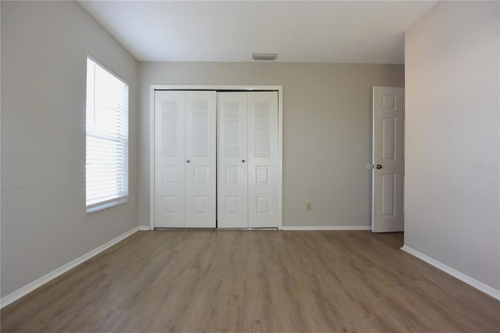 11341 Timbercrest Road Spring Hill, FL 34608 - Photo 24 of 35 an empty room with wooden floor and windows