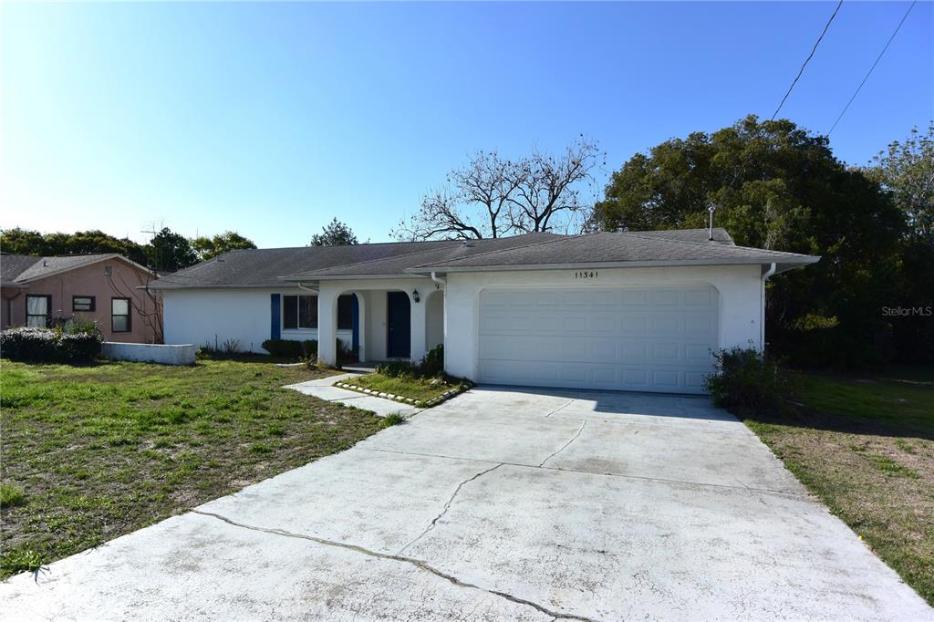 11341 Timbercrest Road Spring Hill, FL 34608 - Photo 26 of 35 a front view of a house with a yard and garage