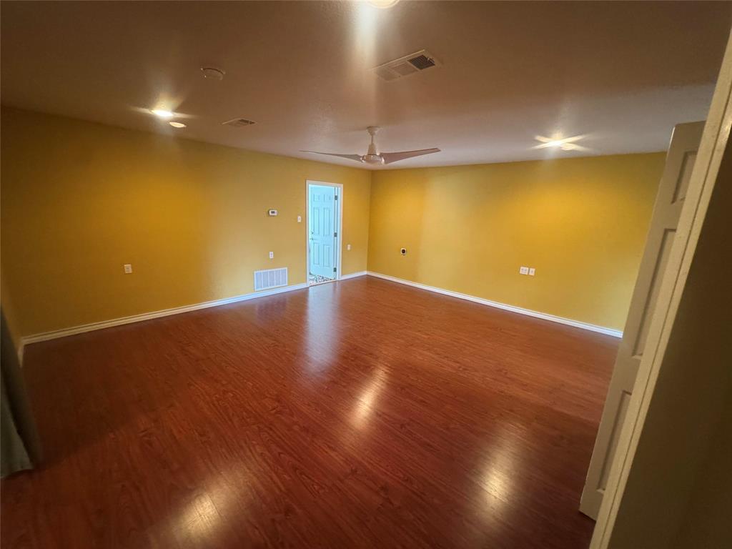 4649 Misty Ridge Drive Fort Worth, TX 76137 - Photo 24 of 25 an empty room with a wooden floor and windows