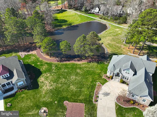 an aerial view of a house with a yard and lake view