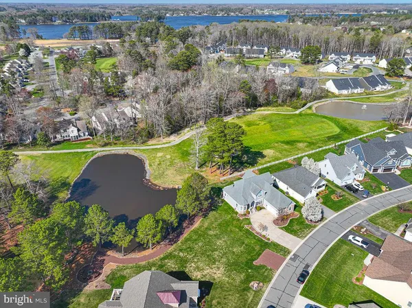 an aerial view of residential houses with outdoor space and trees