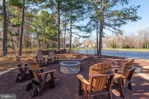 a view of a swimming pool with lawn chairs and wooden fence