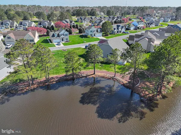 an aerial view of a houses with a garden and lake view
