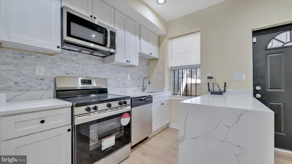 a kitchen with stainless steel appliances a stove microwave and sink