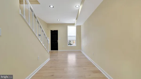 a view of a hallway with wooden floor and staircase