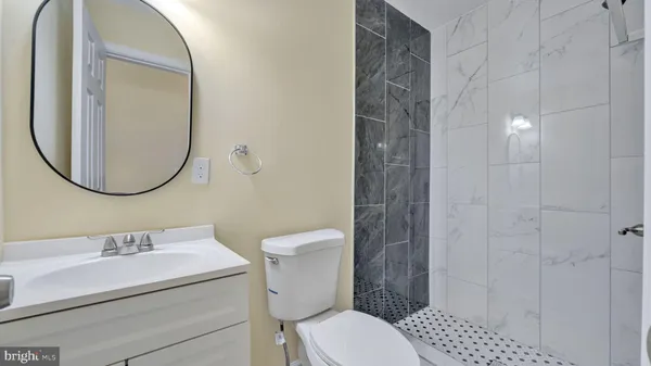 a bathroom with a sink a toilet and a mirror