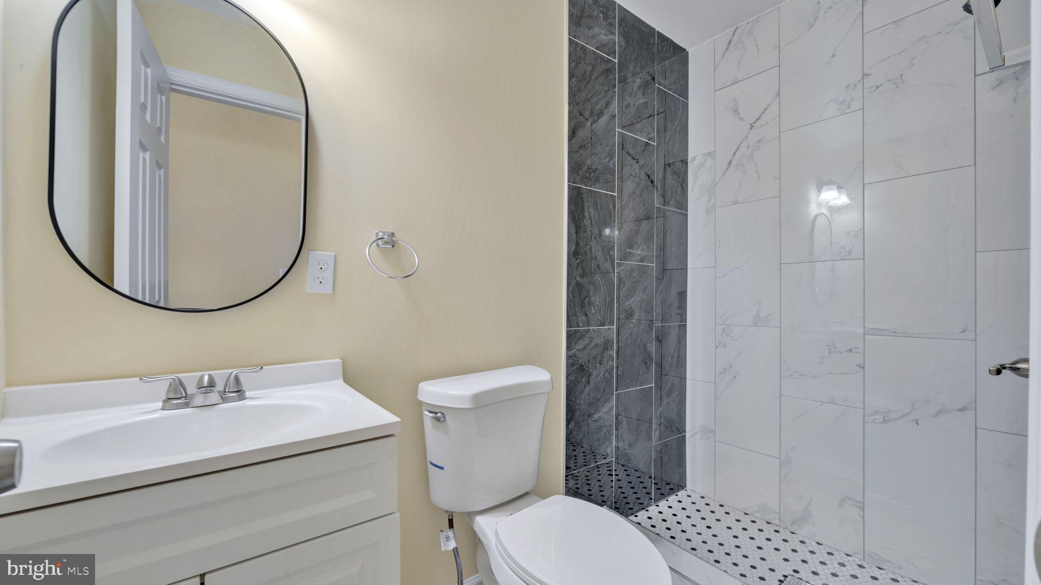 307 South Smallwood Street Baltimore, MD 21223 - Photo 6 of 19 a bathroom with a sink a toilet and a mirror