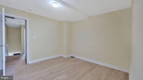 a view of a room with wooden floor and a bathroom