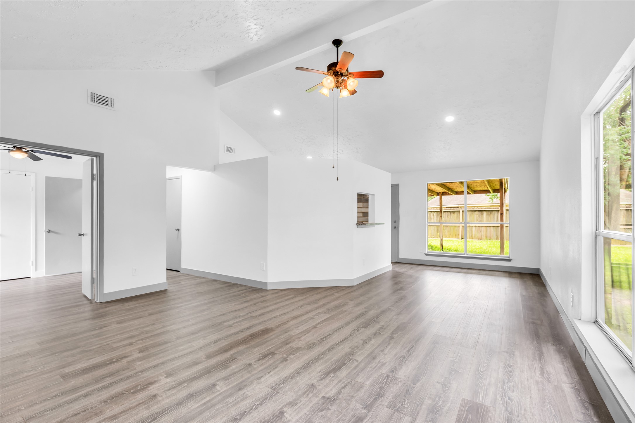 4631 Enchanted Rock Lane Spring, TX 77388 - Photo 6 of 12 A well-lit living area features vaulted ceilings and contemporary flooring, offering an inviting atmosphere.