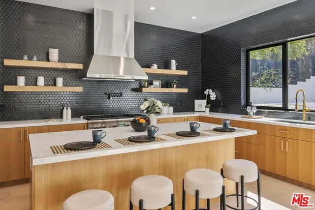 a kitchen with granite countertop a sink a stove and white cabinets