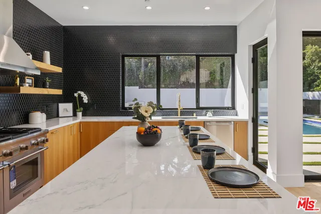 a kitchen with a sink and a stove next to a window