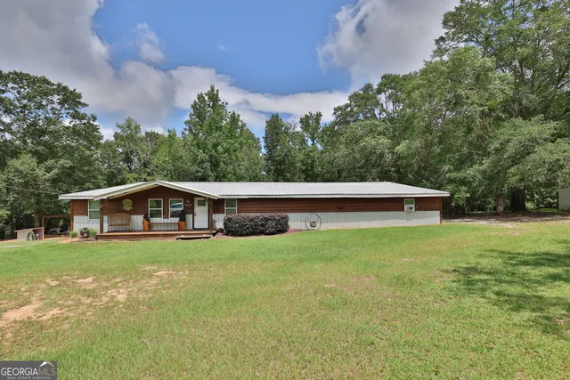 a view of a house with a yard and sitting area