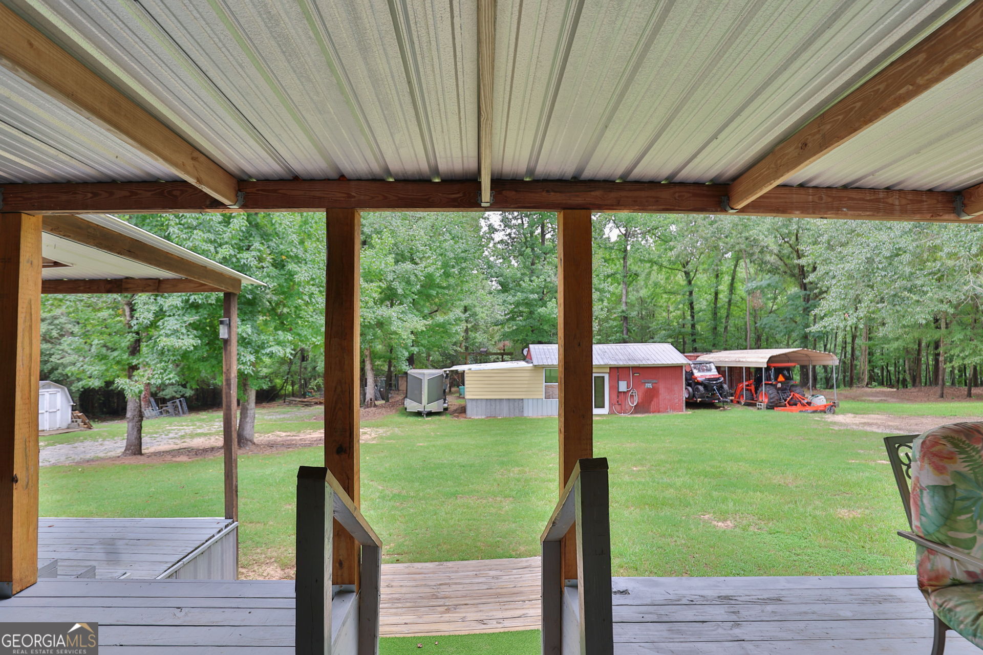 1455 McAllister Road Buena Vista, GA 31803 - Photo 22 of 45 a view of a patio with table and chairs potted plants with wooden floor and fence