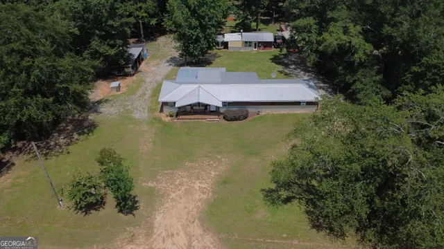 an aerial view of a house with a yard basket ball court and outdoor seating