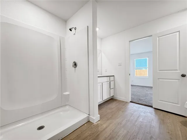 a bathroom with a bathtub shower sink vanity and toilet