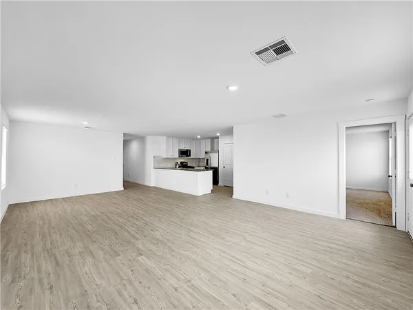 a view of empty room with wooden floor and windows