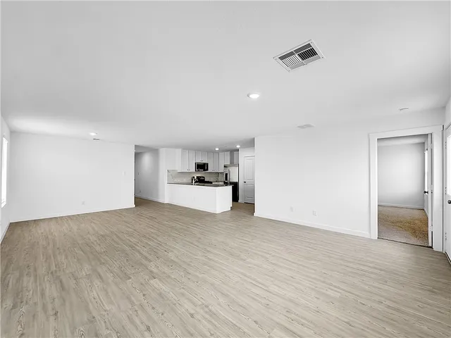a view of empty room with wooden floor and windows