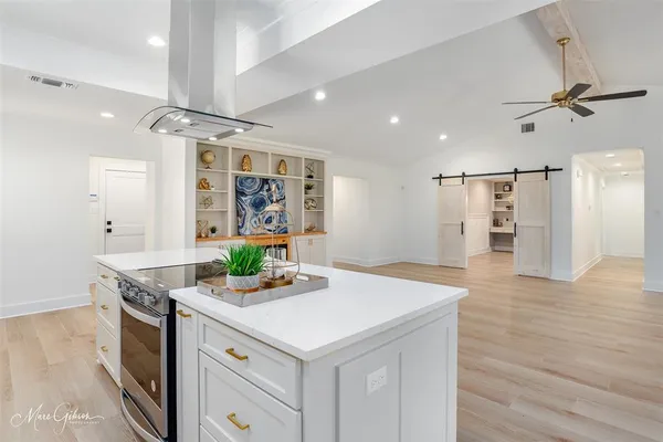 a kitchen with a sink a counter top space and living room view
