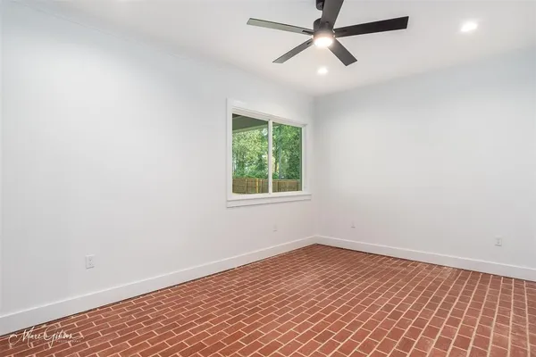 an empty room with a window and a ceiling fan
