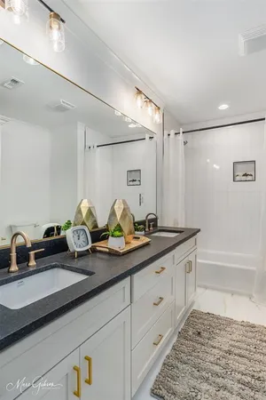 a bathroom with a double vanity sink and a bathtub