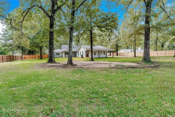 a view of a house with a big yard and sitting area