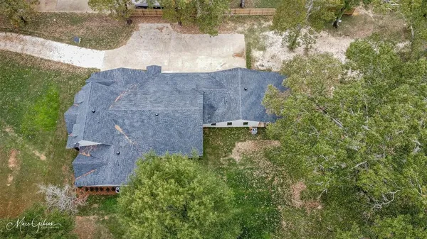 an aerial view of a house with a yard and large tree