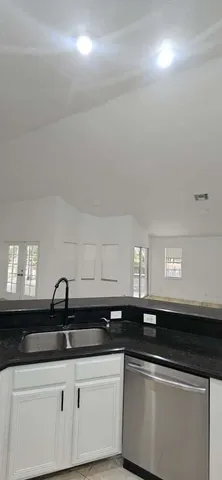 a bathroom with a granite countertop toilet a sink and a mirror
