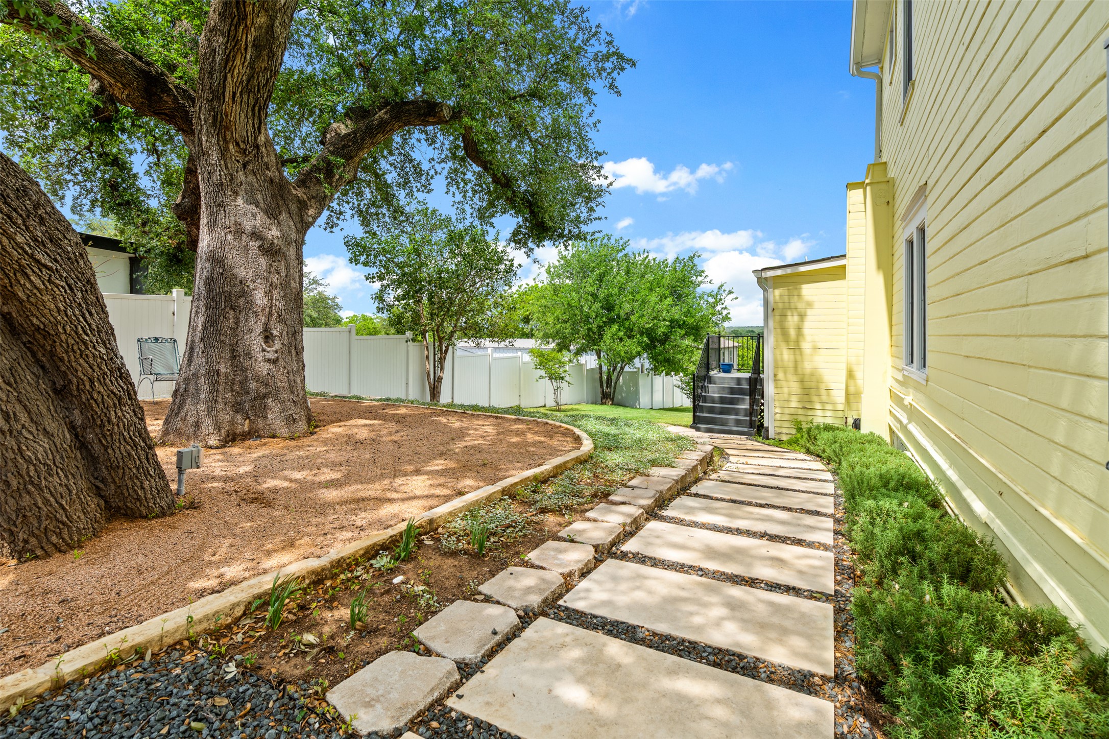 508 Main Street Marble Falls, TX 78654 - Photo 28 of 30 View of side yard with pavers that lead up to back elevated deck.