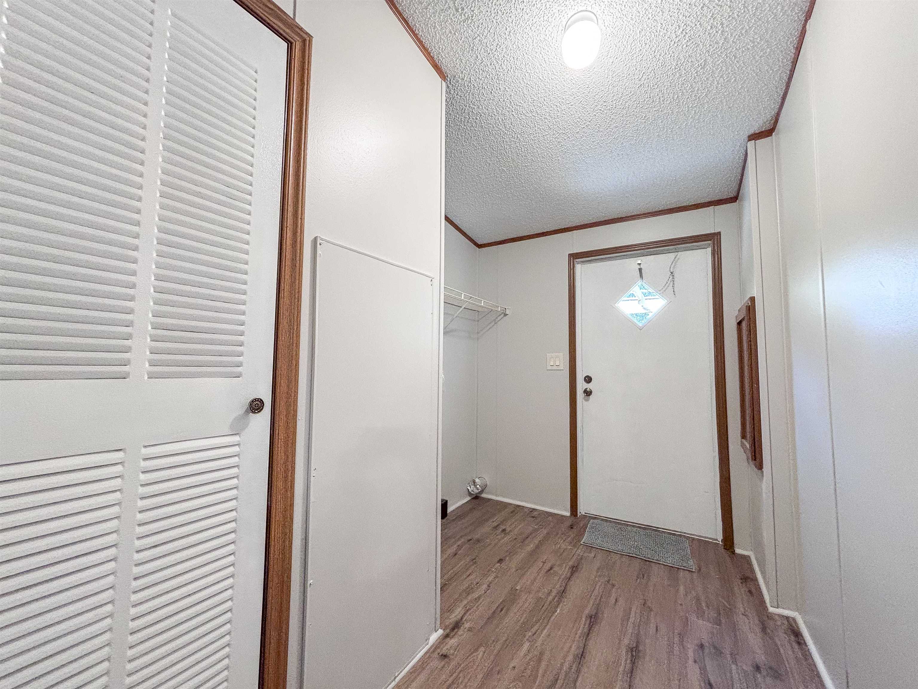 2847 Holly Grove Road Covington, TN 38019 - Photo 28 of 36 Entryway featuring wood-finish flooring, white paneled walls, and a white front door with decorative glass inlay