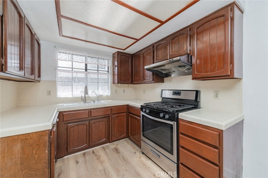 232 West Mission Road, Unit C San Gabriel, CA 91776 - Photo 4 of 11 a kitchen with stainless steel appliances granite countertop wooden cabinets stove top oven and sink