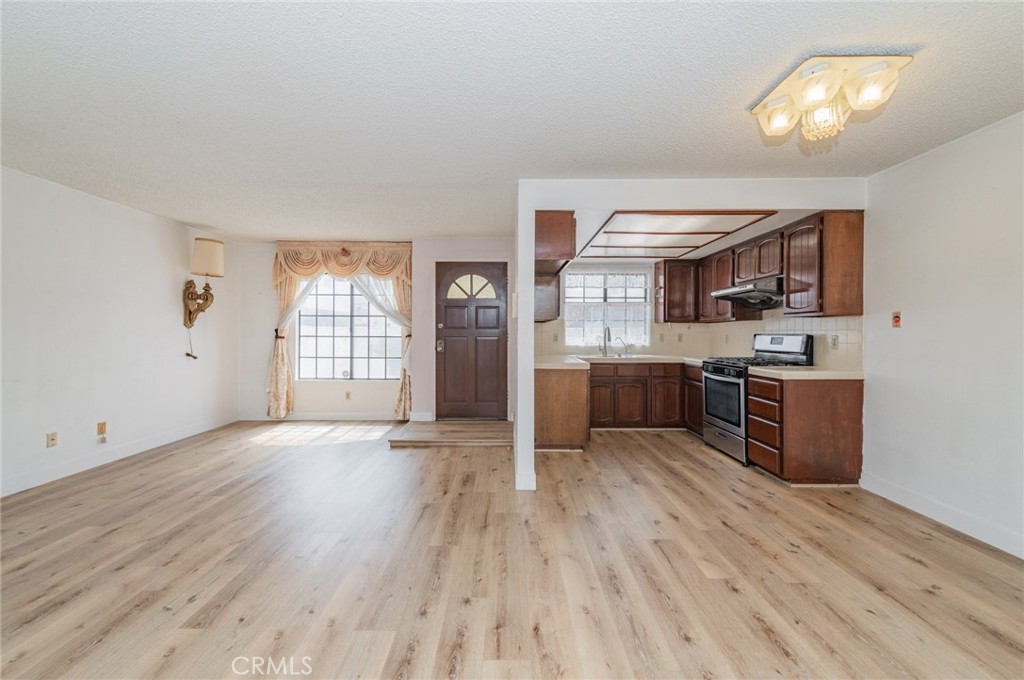232 West Mission Road, Unit C San Gabriel, CA 91776 - Photo 5 of 11 a kitchen with stainless steel appliances granite countertop a stove top oven a sink with wooden floors and cabinets