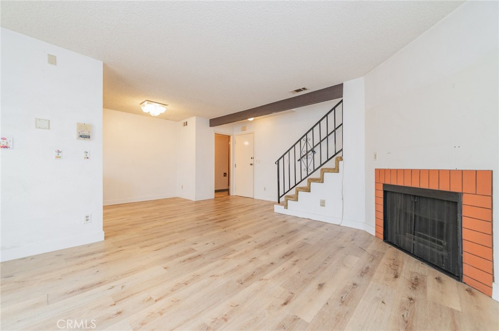232 West Mission Road, Unit C San Gabriel, CA 91776 - Photo 6 of 11 a view of empty room with wooden floor and fireplace