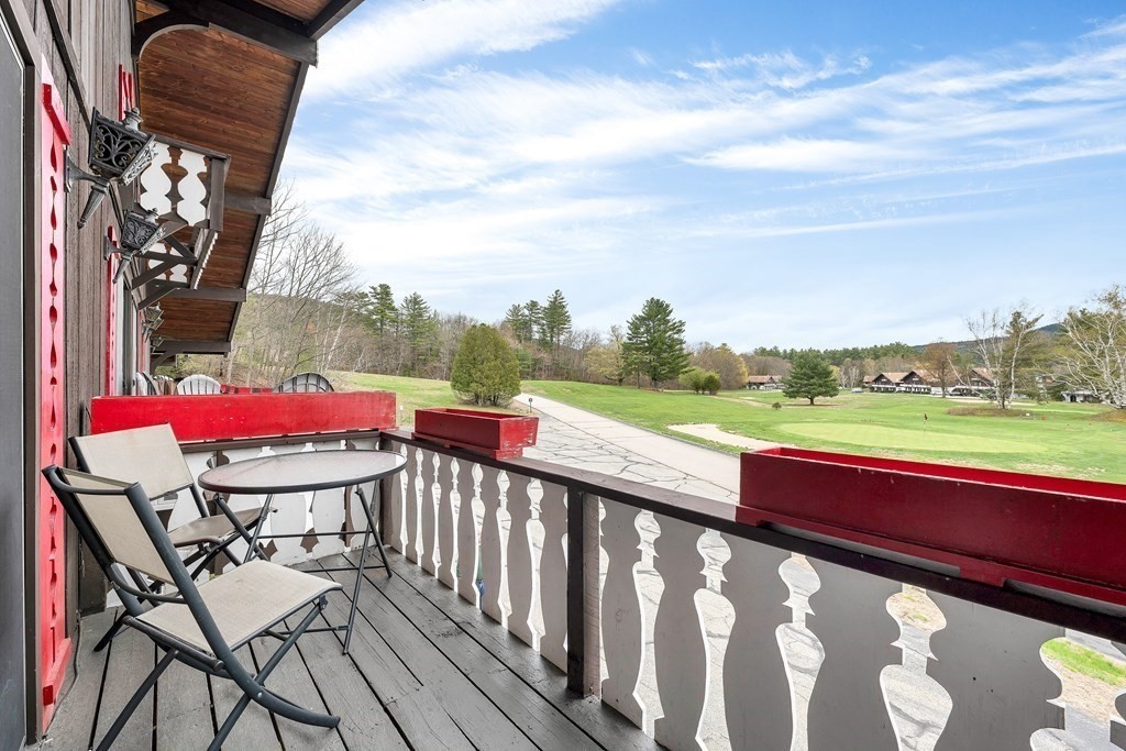 34 Linderhof Golf Course Road, Unit C12 Glen, NH 03838 - Photo 13 of 37 a balcony with wooden floor table and chairs