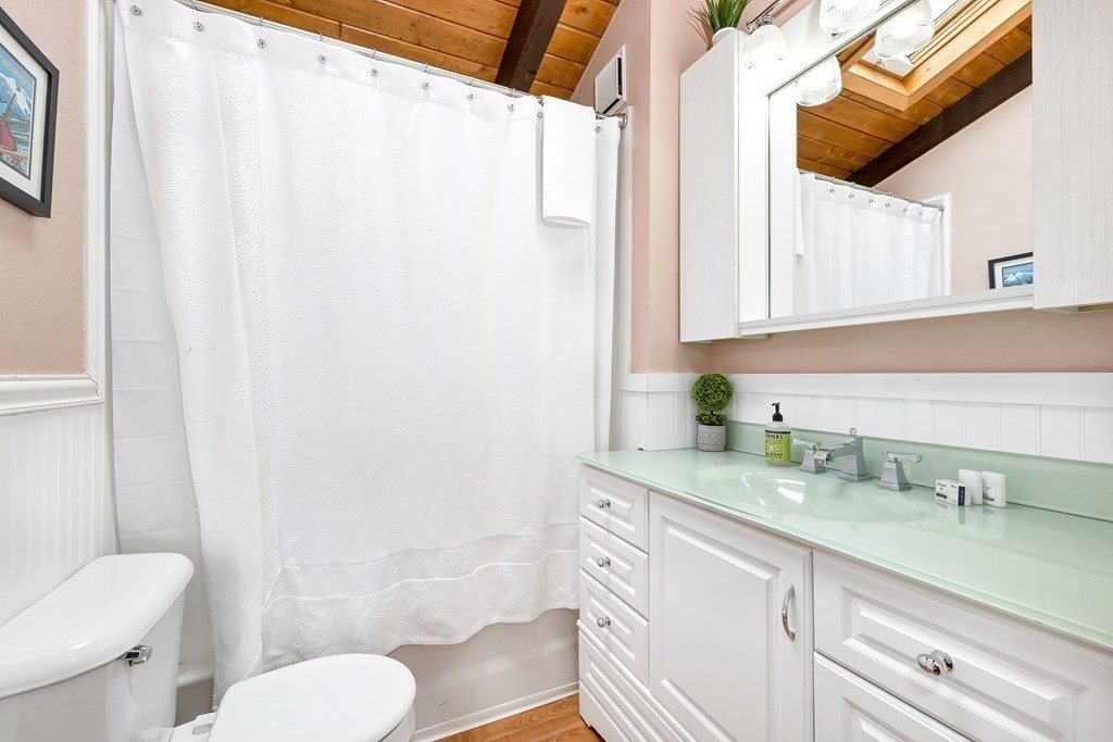34 Linderhof Golf Course Road, Unit C12 Glen, NH 03838 - Photo 20 of 37 a bathroom with a granite countertop sink mirror vanity and toilet