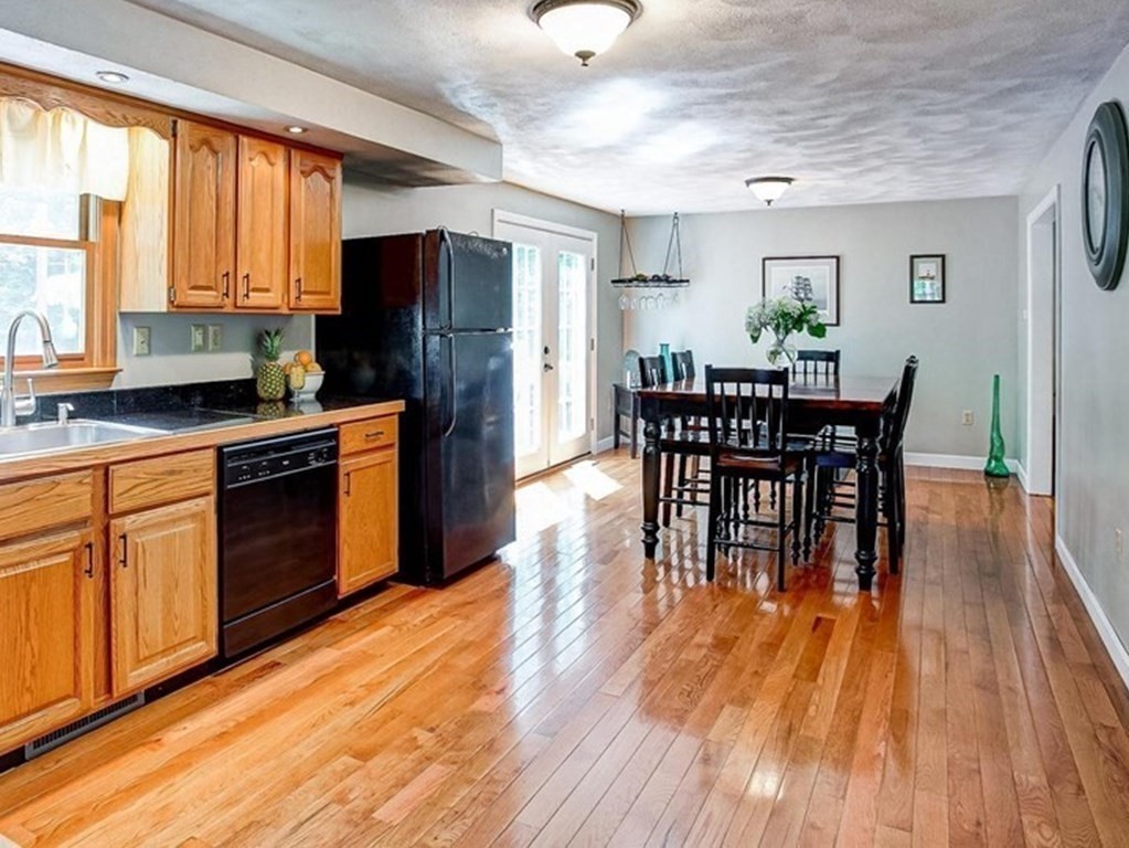 226 Allen Road Billerica, MA 01821 - Photo 11 of 25 a kitchen with stainless steel appliances granite countertop wooden floor dining table and chairs