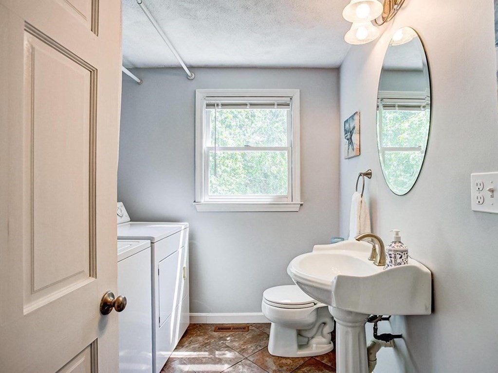 226 Allen Road Billerica, MA 01821 - Photo 13 of 25 a bathroom with a sink a mirror a toilet and a window