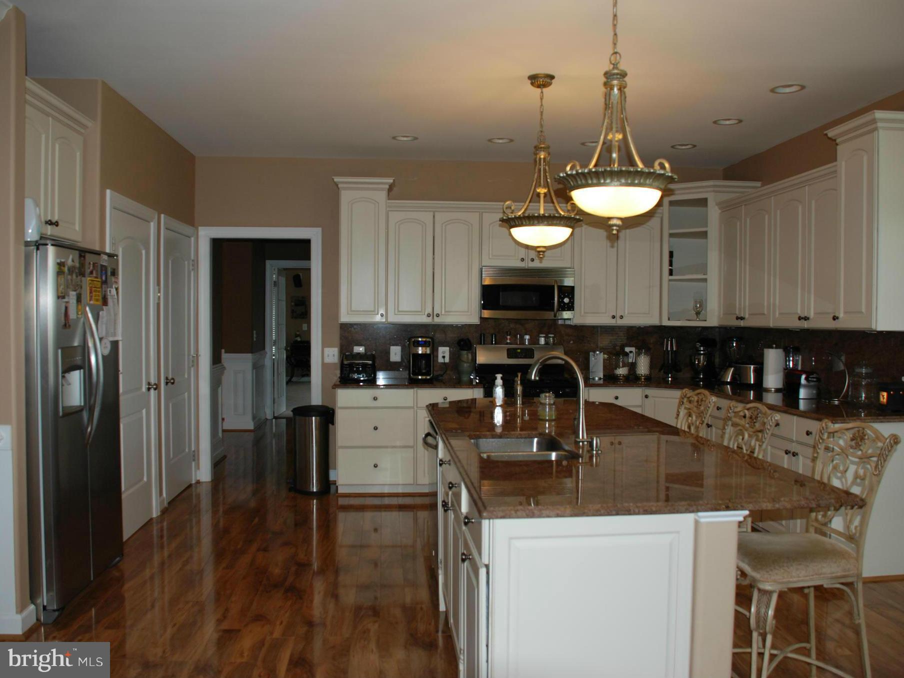 6015 Boston Ridge Court Boston, VA 22713 - Photo 8 of 30 a kitchen with stainless steel appliances granite countertop a sink a stove a refrigerator cabinets and chairs