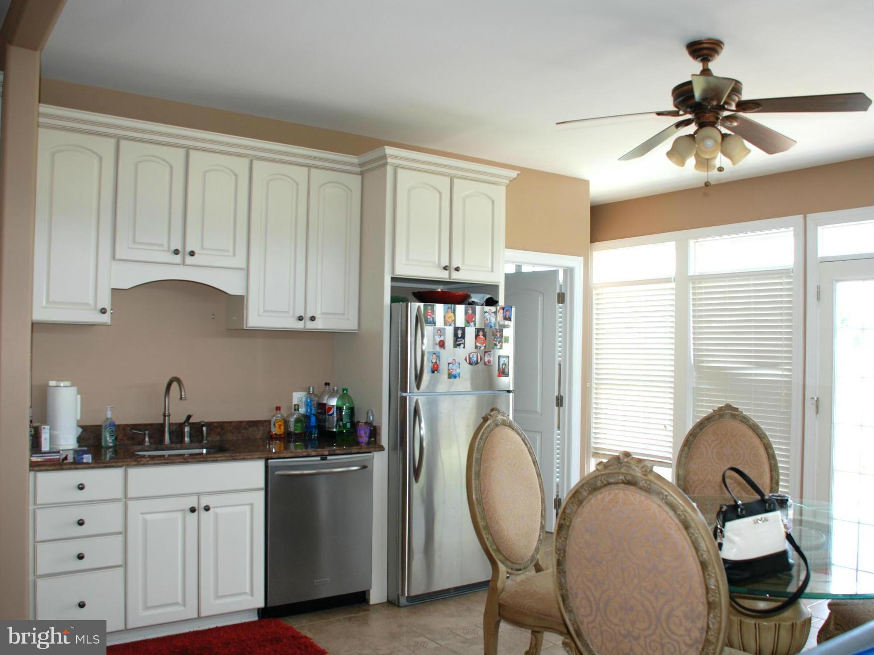 6015 Boston Ridge Court Boston, VA 22713 - Photo 9 of 30 a kitchen with sink refrigerator dining table and cabinets