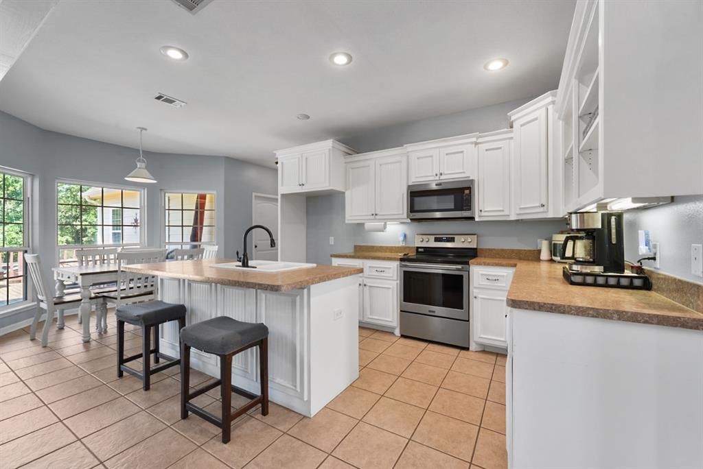 155 Rs County Road Emory, TX 75440 - Photo 12 of 31 a kitchen with granite countertop a stove a sink and a microwave