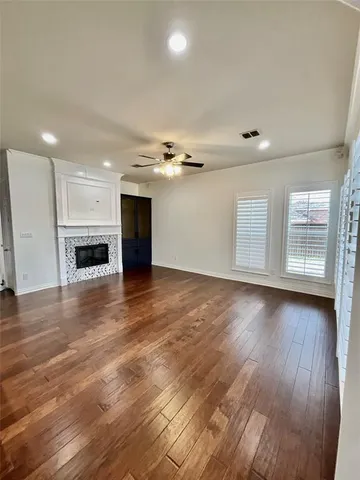 an empty room with wooden floor and fireplace