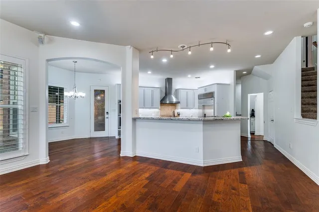 a view of kitchen with kitchen island wooden cabinets and refrigerator