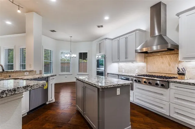 a kitchen with kitchen island granite countertop a stove and a sink