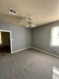 an empty room with windows and fan